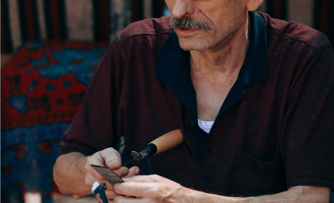 An artisan making a tobacco pipe using a lathe.